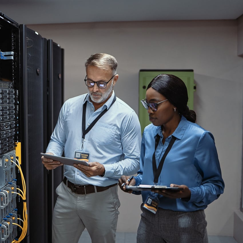 Two coworkers walking together working in a datacenter
