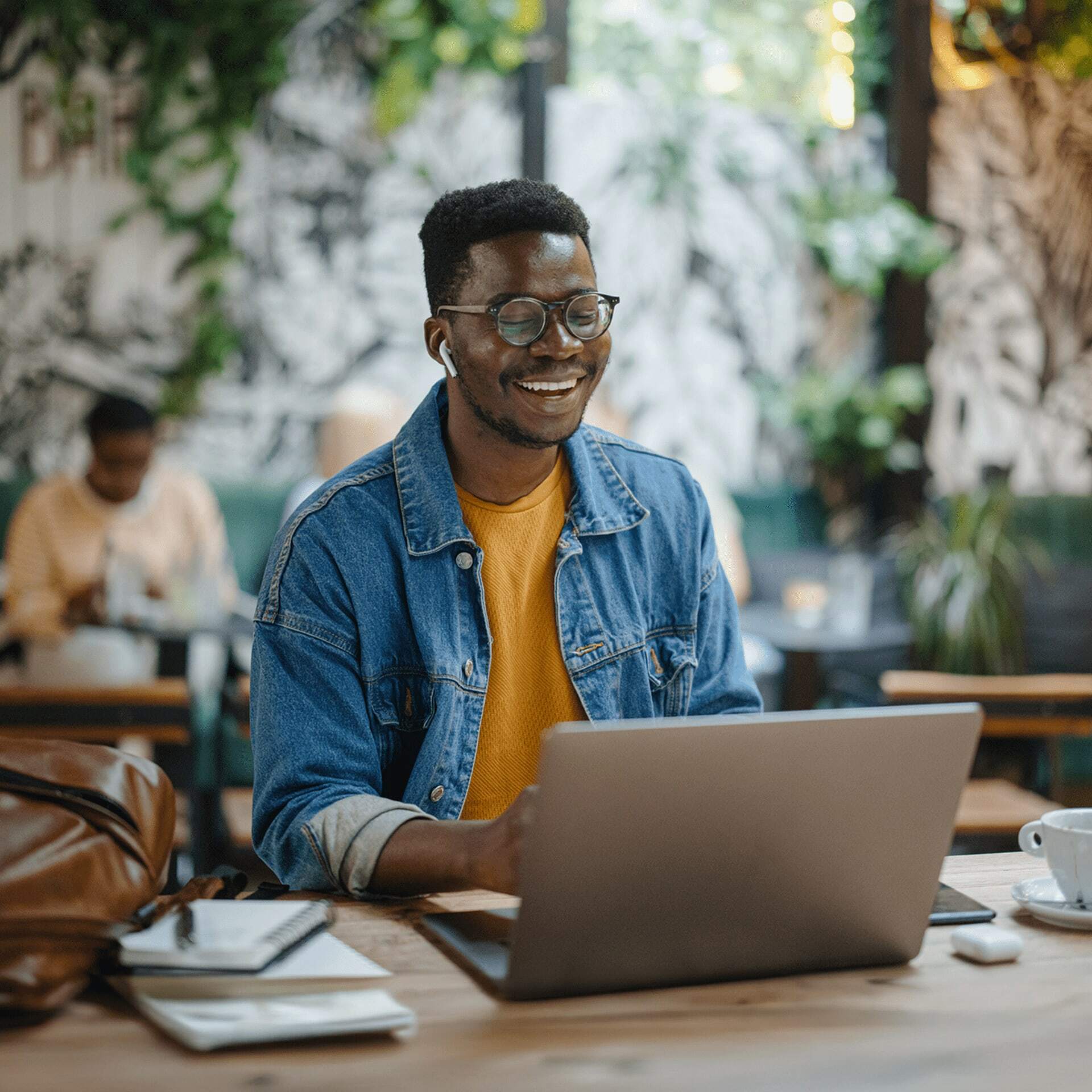 A young man wearing glasses creating his perfect cv on a laptop