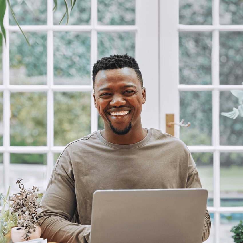 Smiling man research cost of university online degrees.
