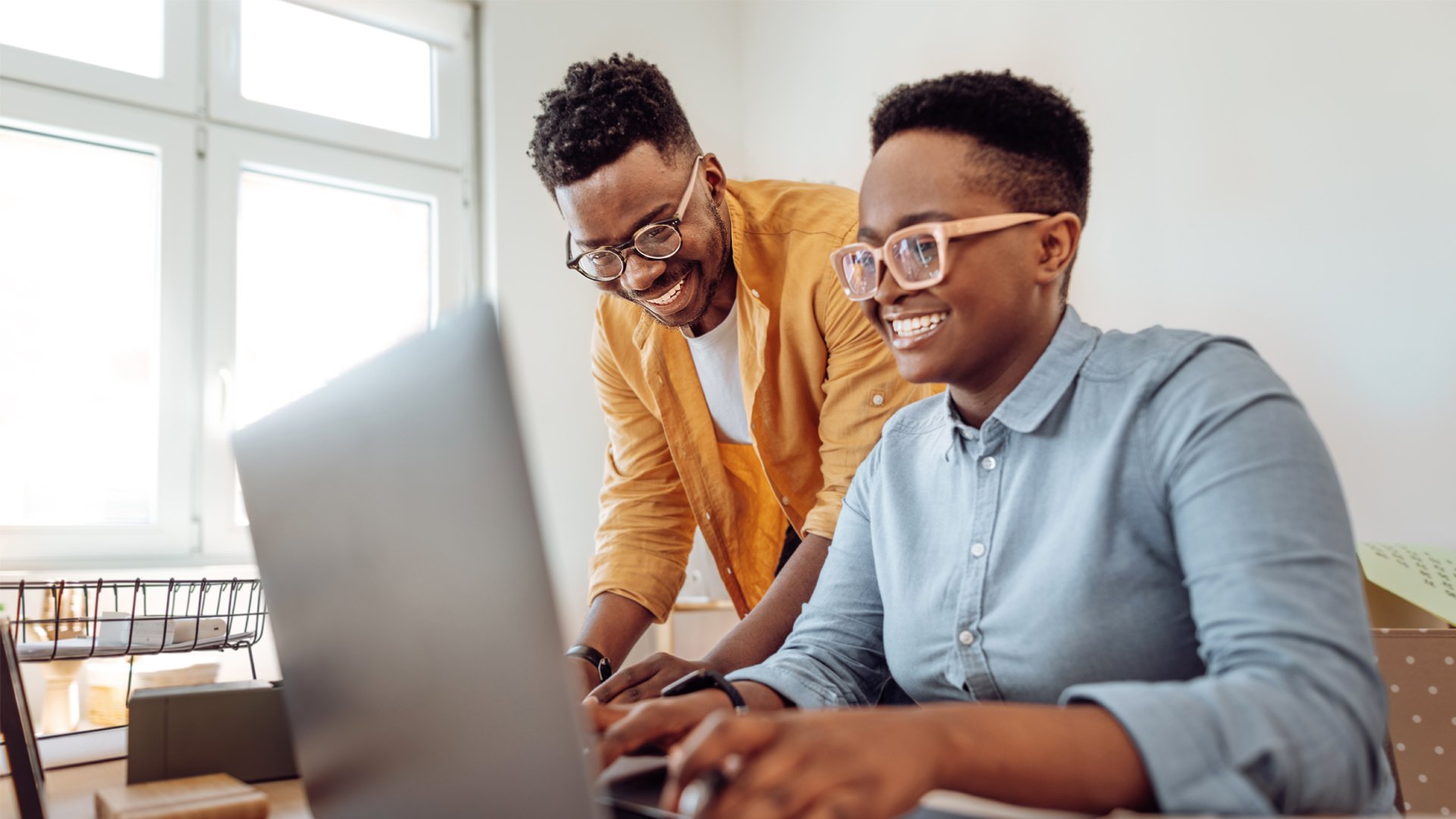 Two students working together on a laptop, checking January start details for data security and data science courses.