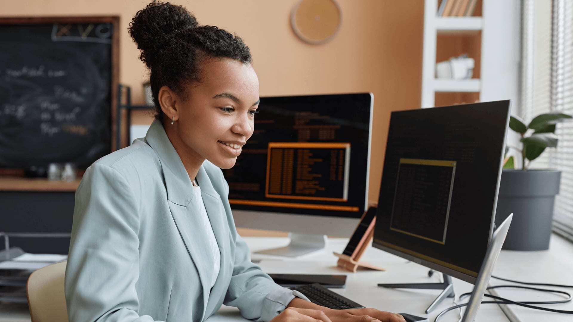 Young woman in blue blazer studies online degree at home.