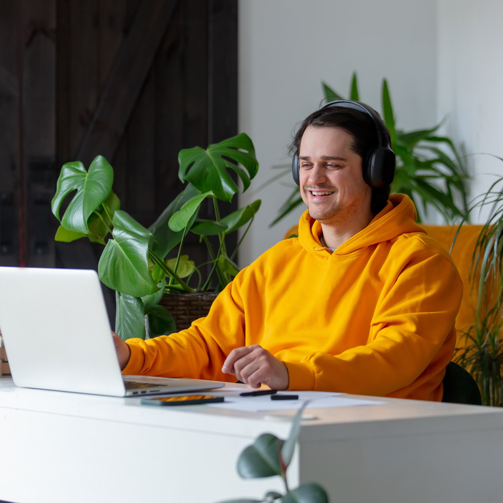 Man in yellow hoodie and headphones revising for exams using tips to stay motivated.