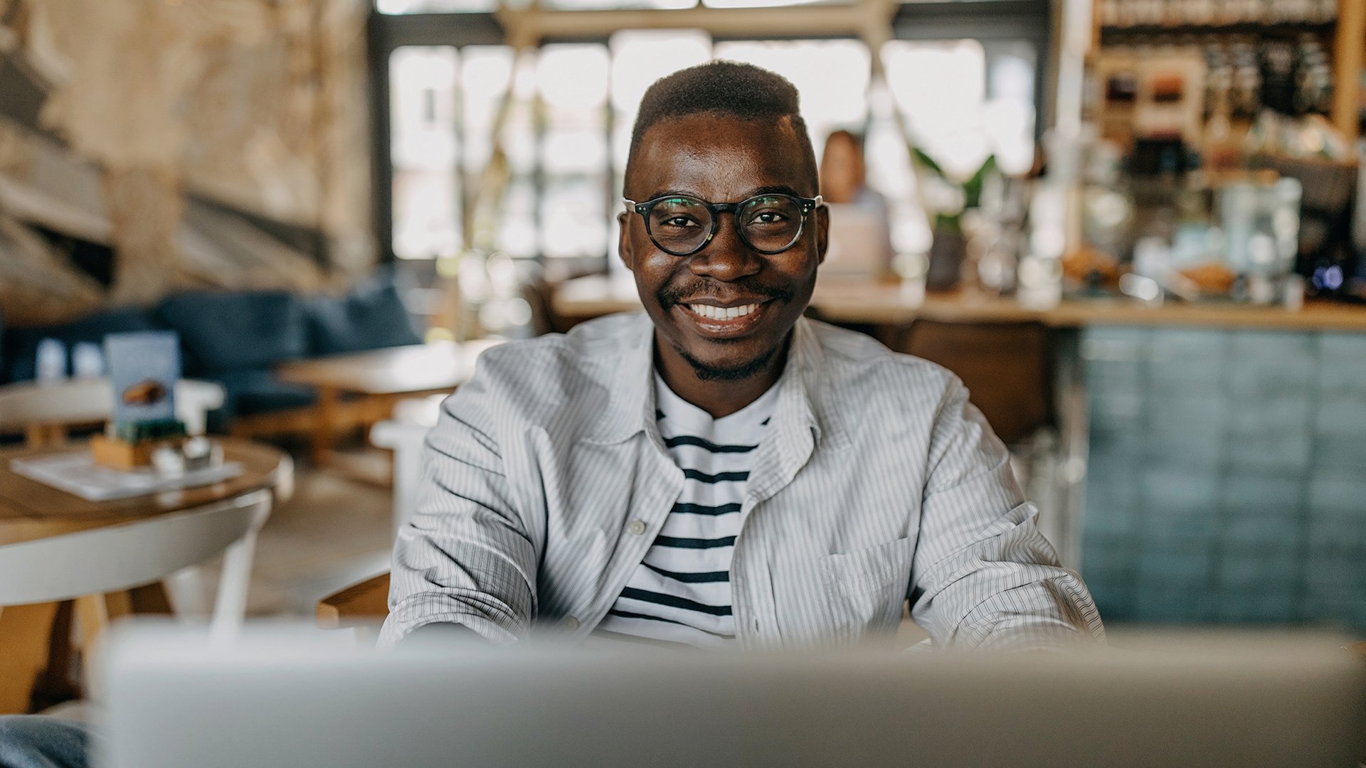 Man joining e learning students working on skills and assignments from a cafe.