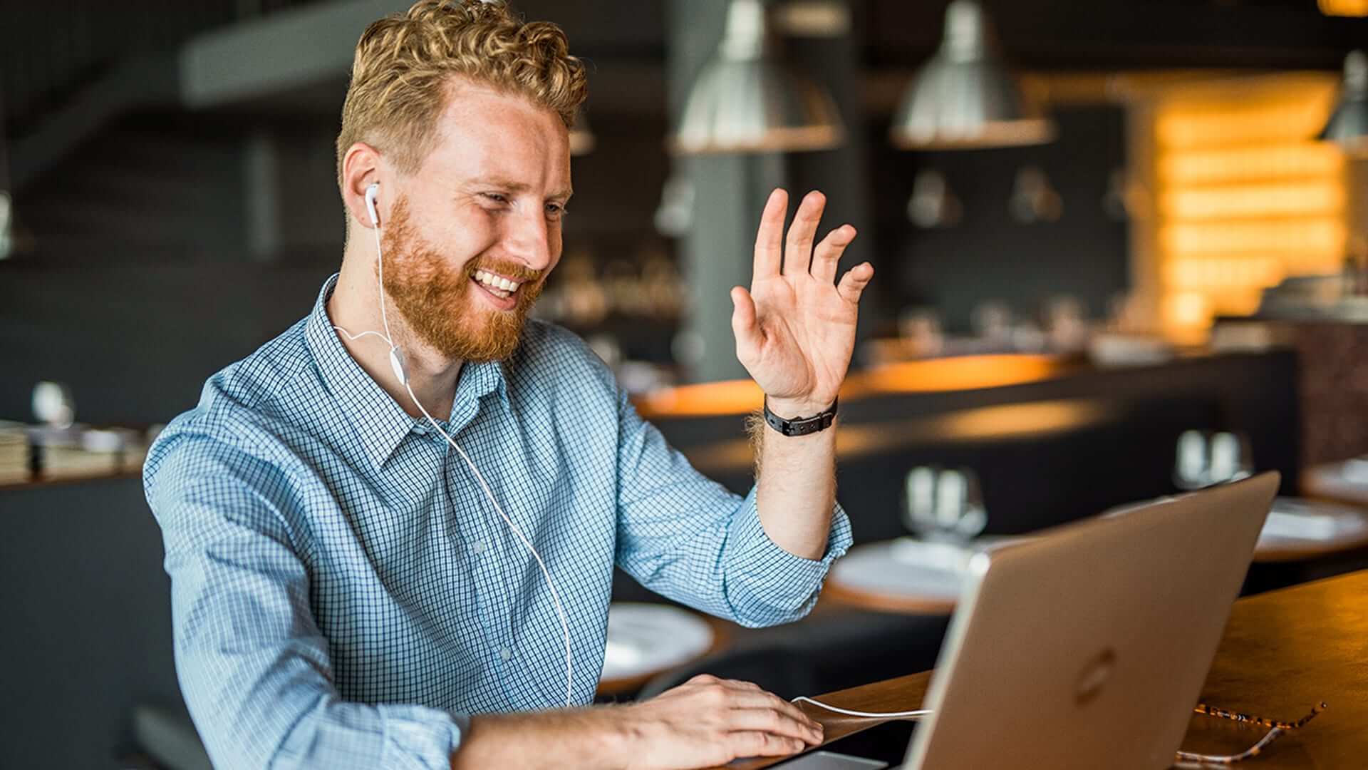A man sitting at a desk, smiling while talking to someone off camera.