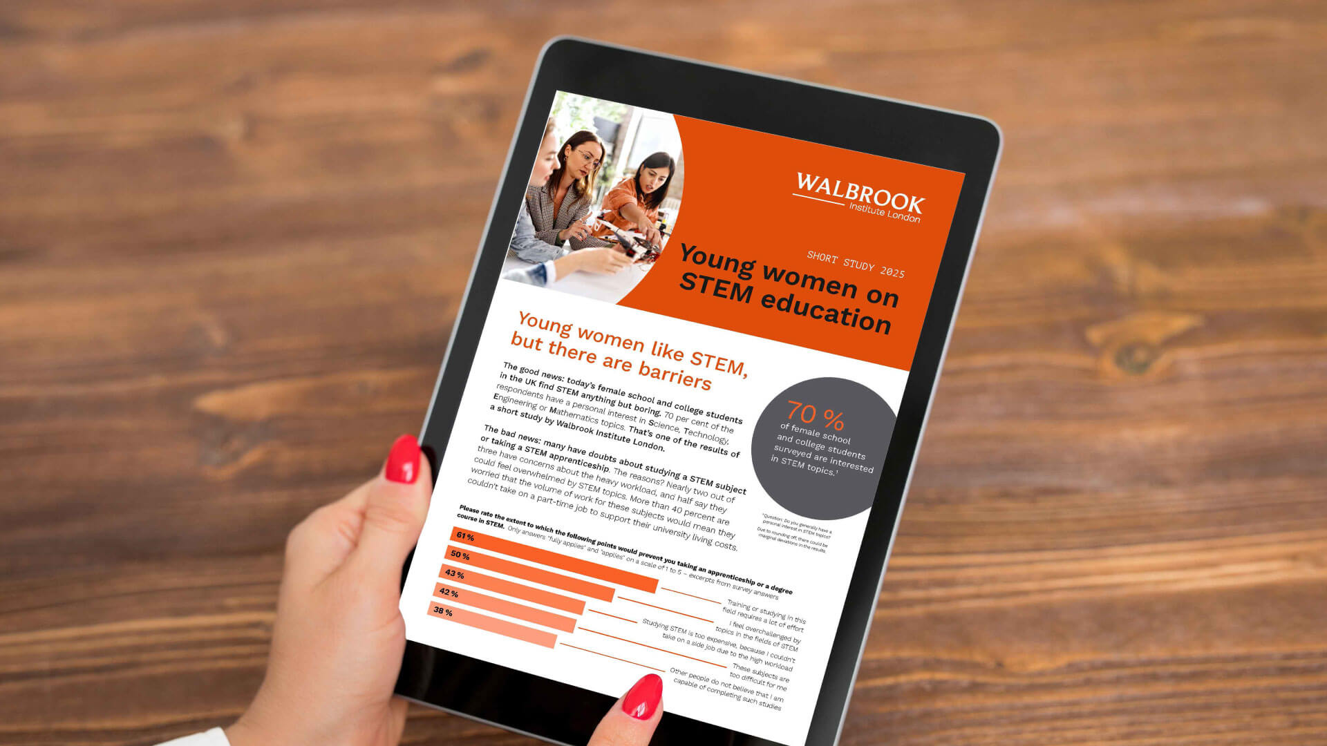 A person holding a tablet displaying the Young Women in STEM report..