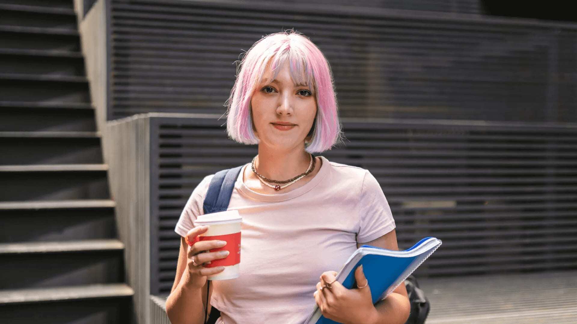 Woman with pink hair holding coffee prepares for AI software engineering interview.