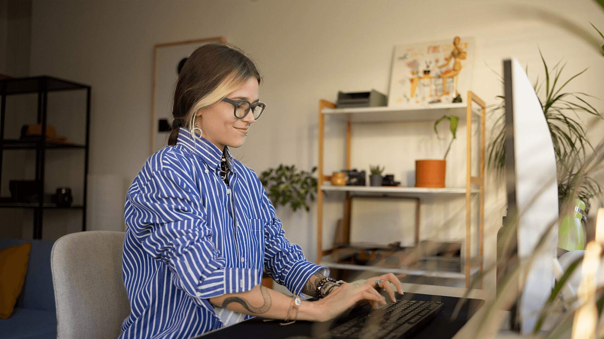 Woman in striped shirt and glasses learning key concepts of AI for computer science.