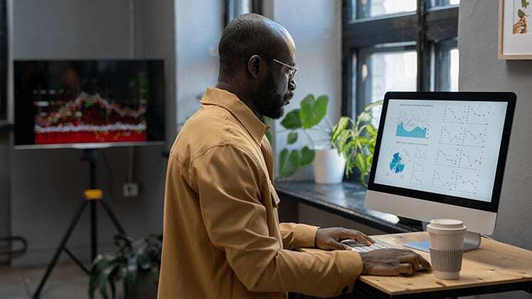 Male data scientist at desktop computer problem solving with AI.