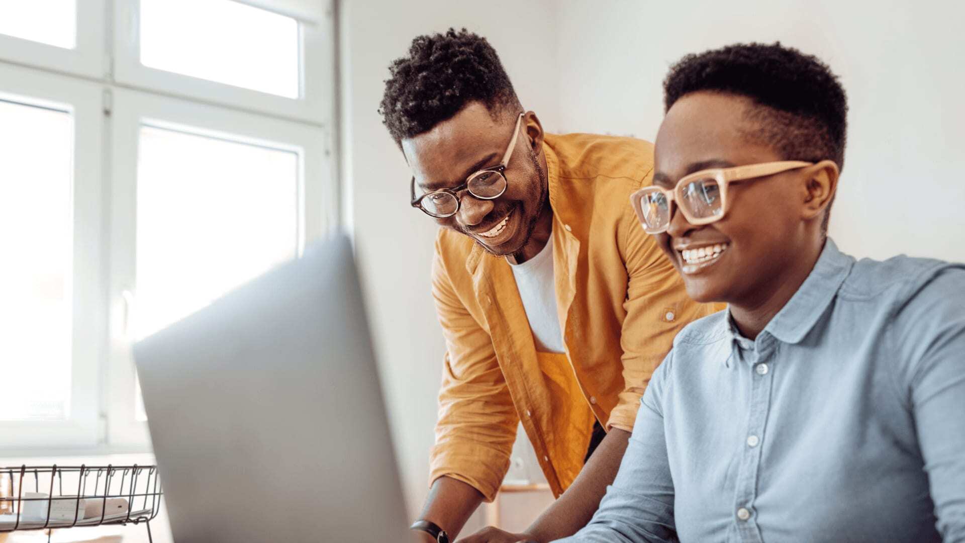 Two research scientists in glasses and shirts working using an AI to help their work.