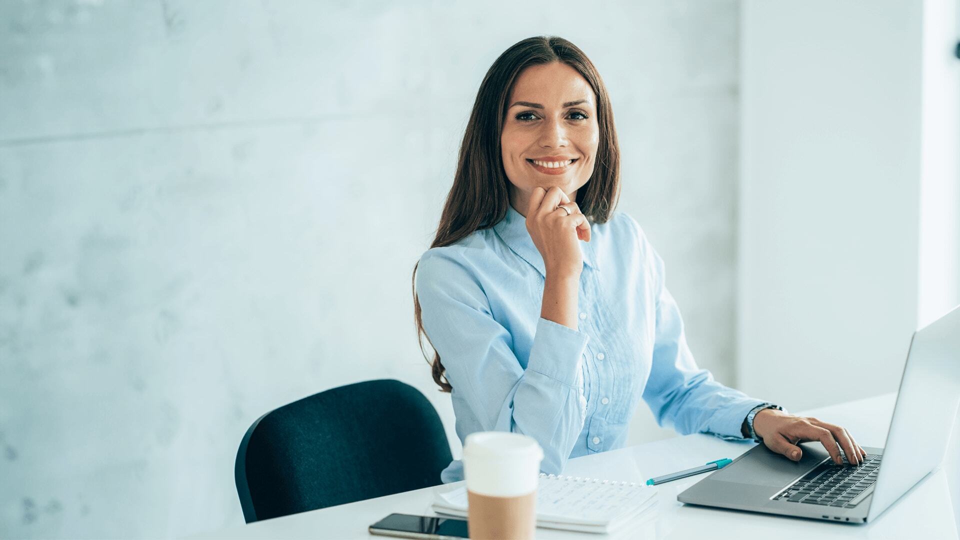 Woman working on software engineering from a laptop in a modern office.