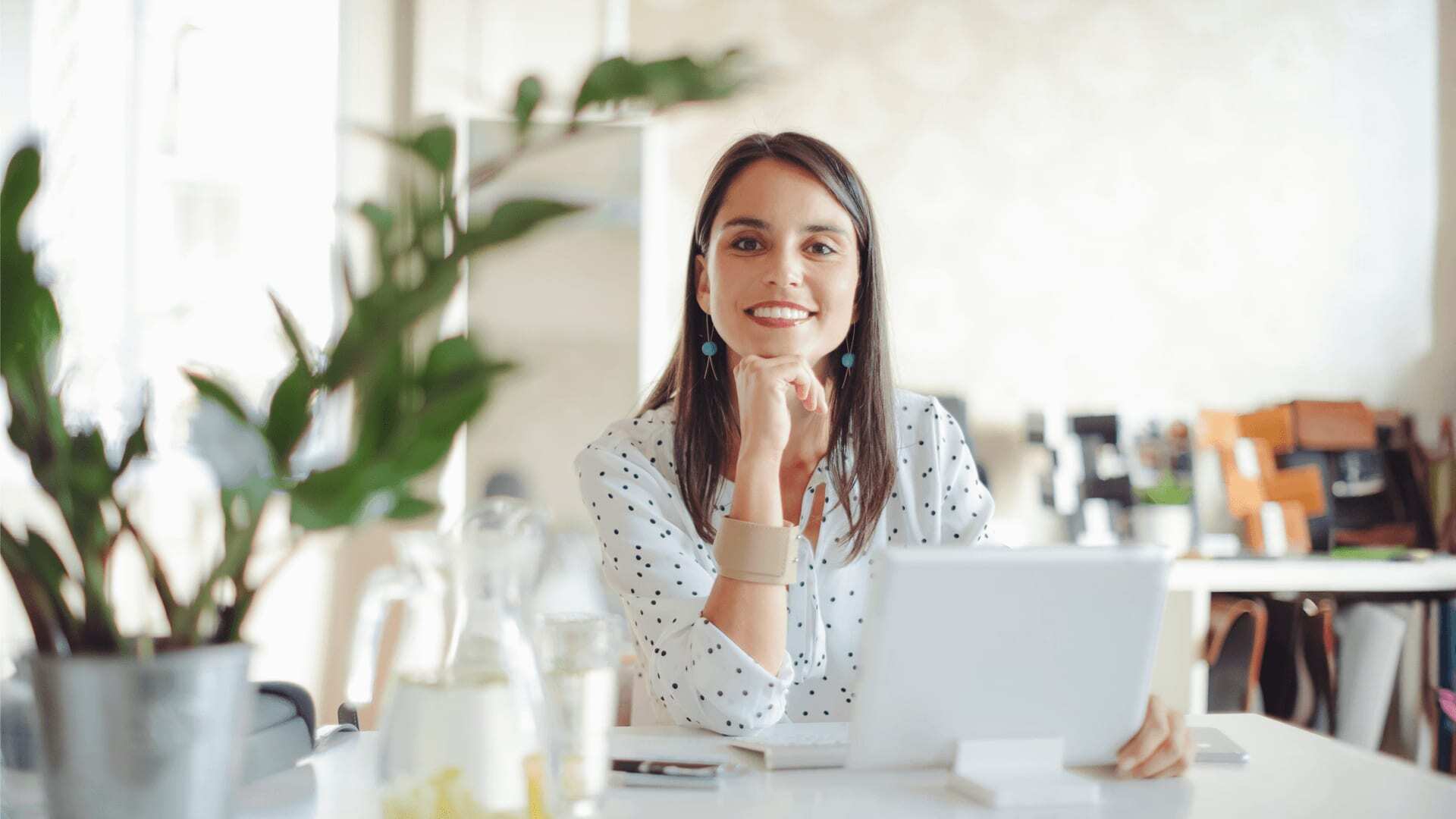 A software developer working on a tablet, using agile software development practices and a programming language in a modern, bright workspace