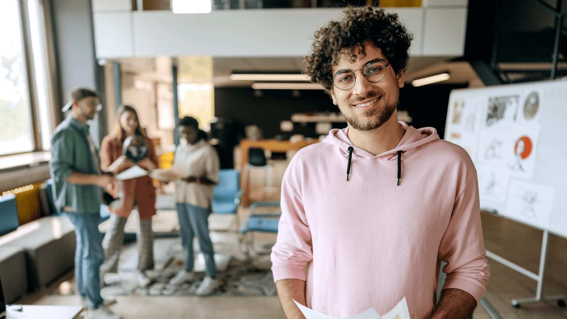 Man in pink hoodie leads a team of AI engineers using critical thinking to improve an AI product.