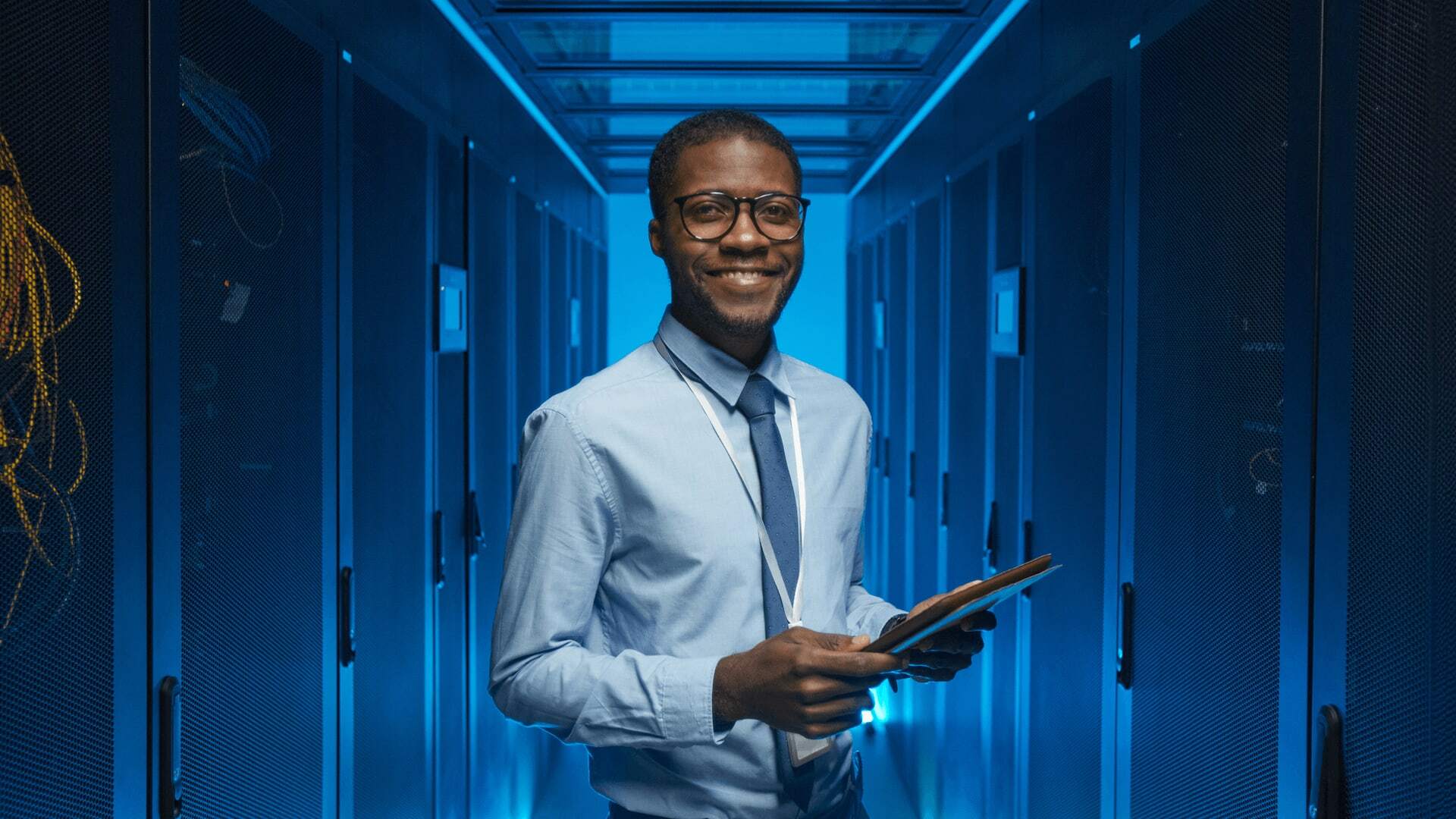 Data professional in a server room ensuring organization and infrastructure meets the required standards, having viewed past performance to align roles with future needs