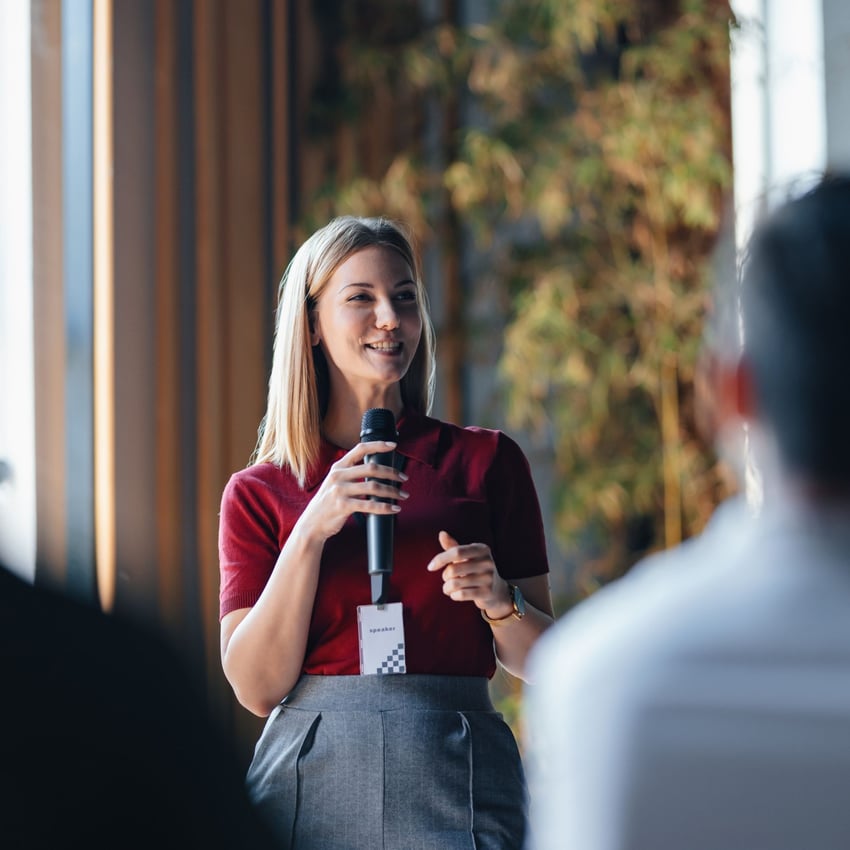 Woman giving a talk through a microphone to others