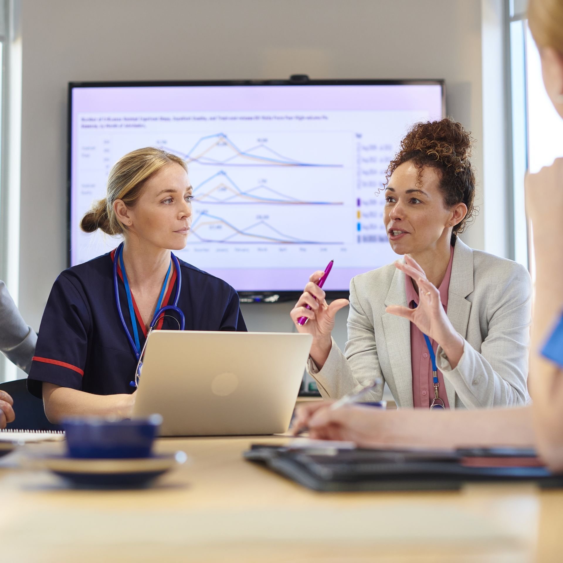 A woman in a medical advisory role discusses something during a meeting