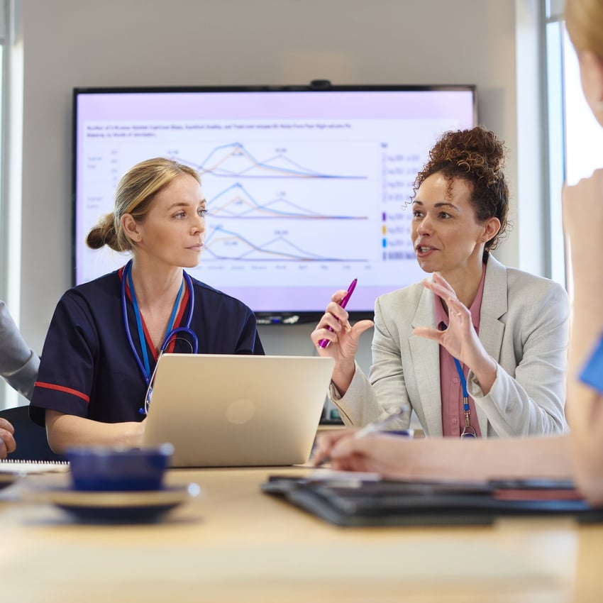 A woman in a medical advisory role discusses something during a meeting