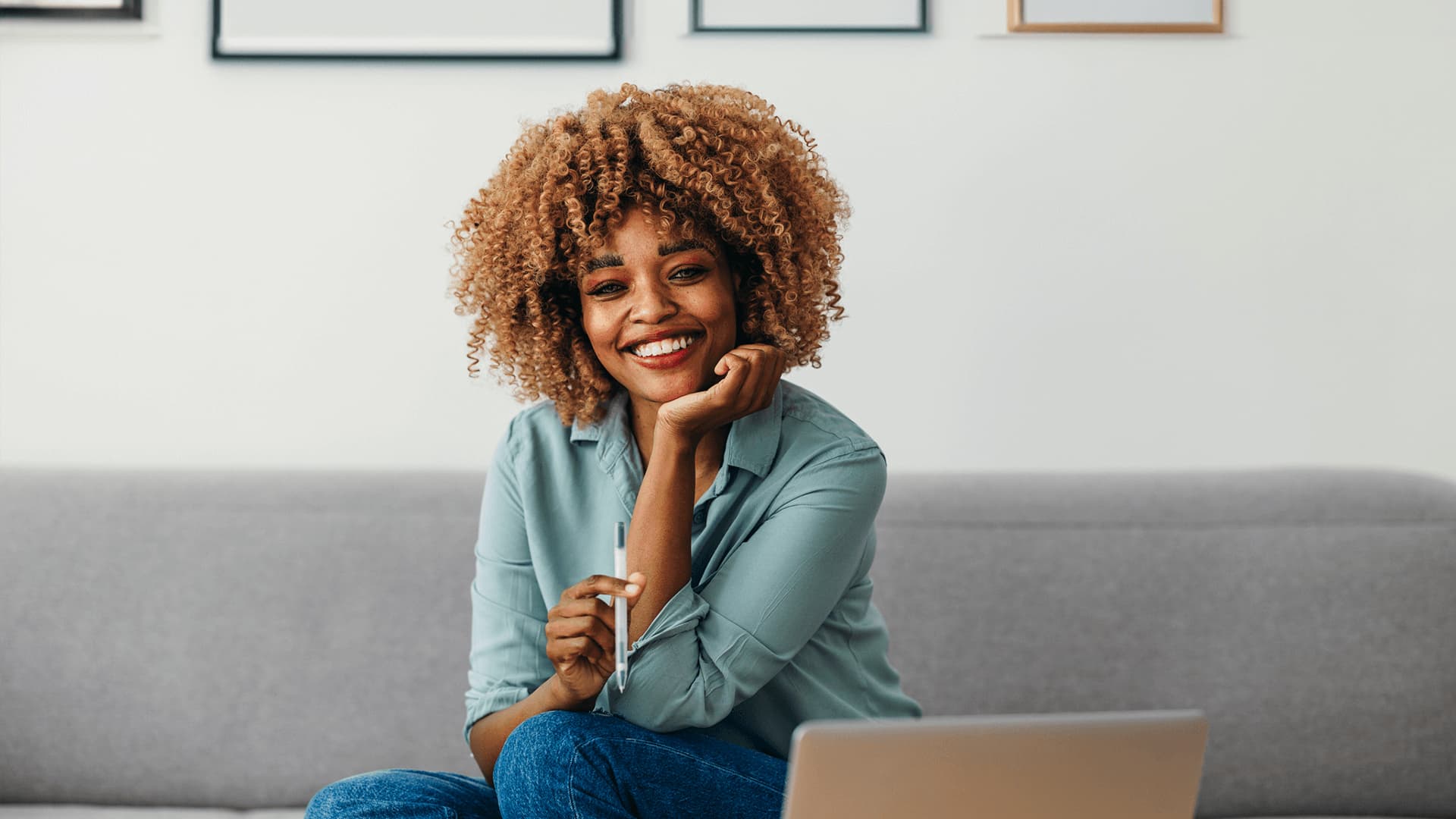 Woman with curly hair at laptop research starting salary after studying an MBA with a business school.