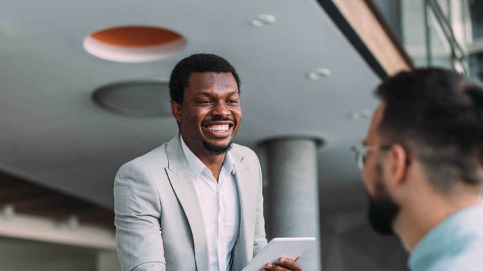 Online MBA graduate in a suit, in a meeting, discussing business ideas.