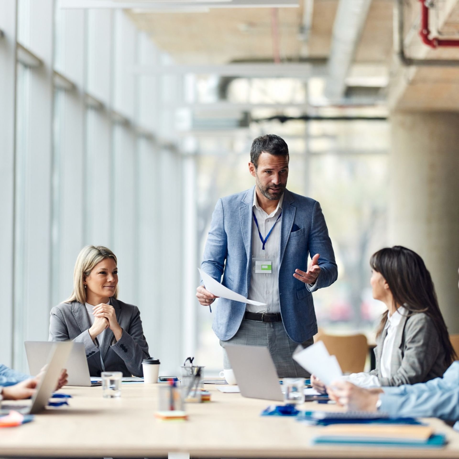 Man standing up and talking during a meeting with colleagues