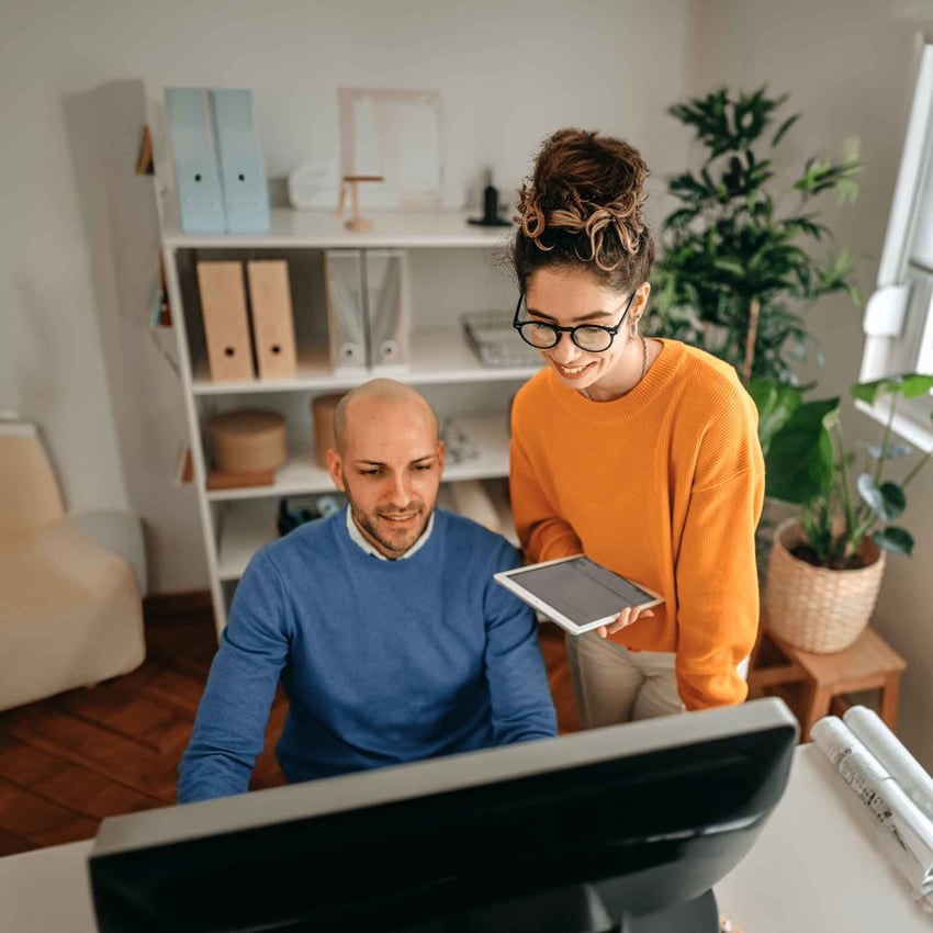 Two AI professionals using desktop and tablet to learn the right skills in AI.