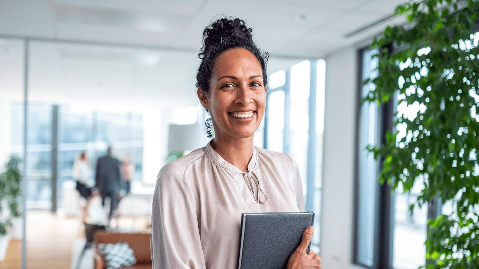 Female artificial intelligence developer holding ipad in modern software engineering office.
