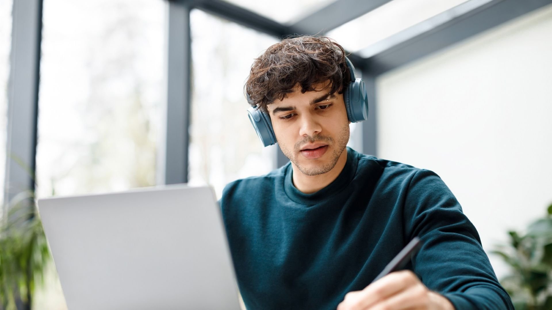 Student working on a laptop and notepad in home environment