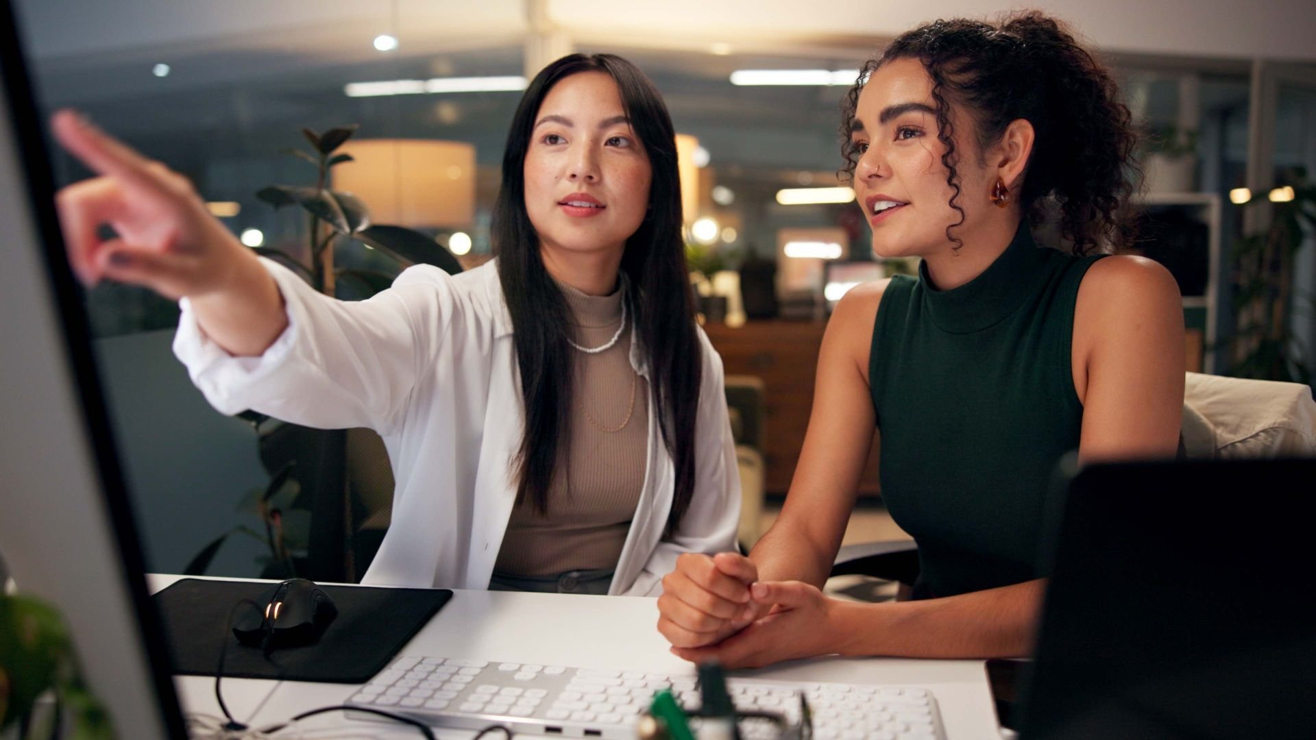 Two women discussing and pointing at a computer screen