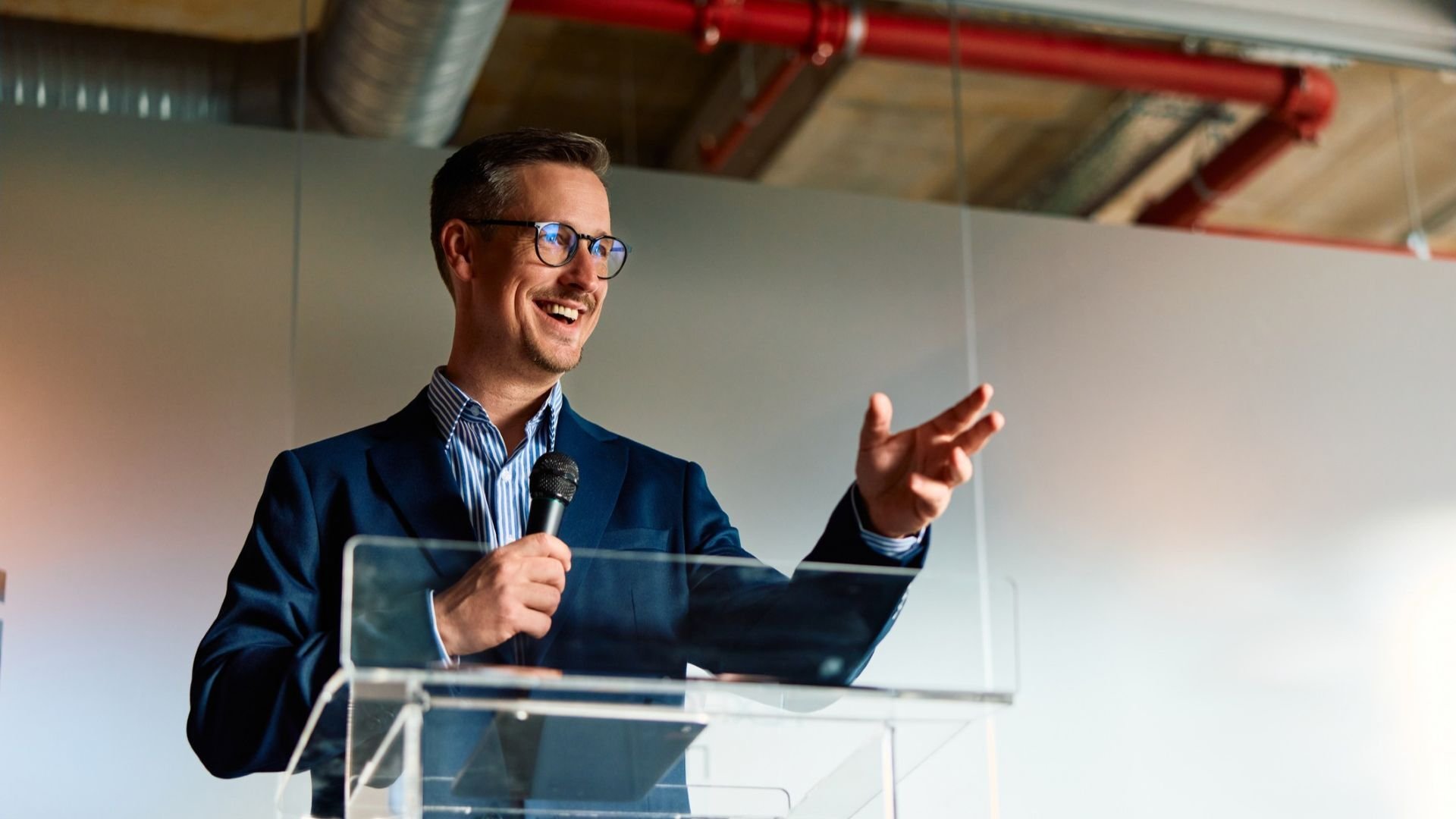Man giving a talk through a microphone in a corporate environment