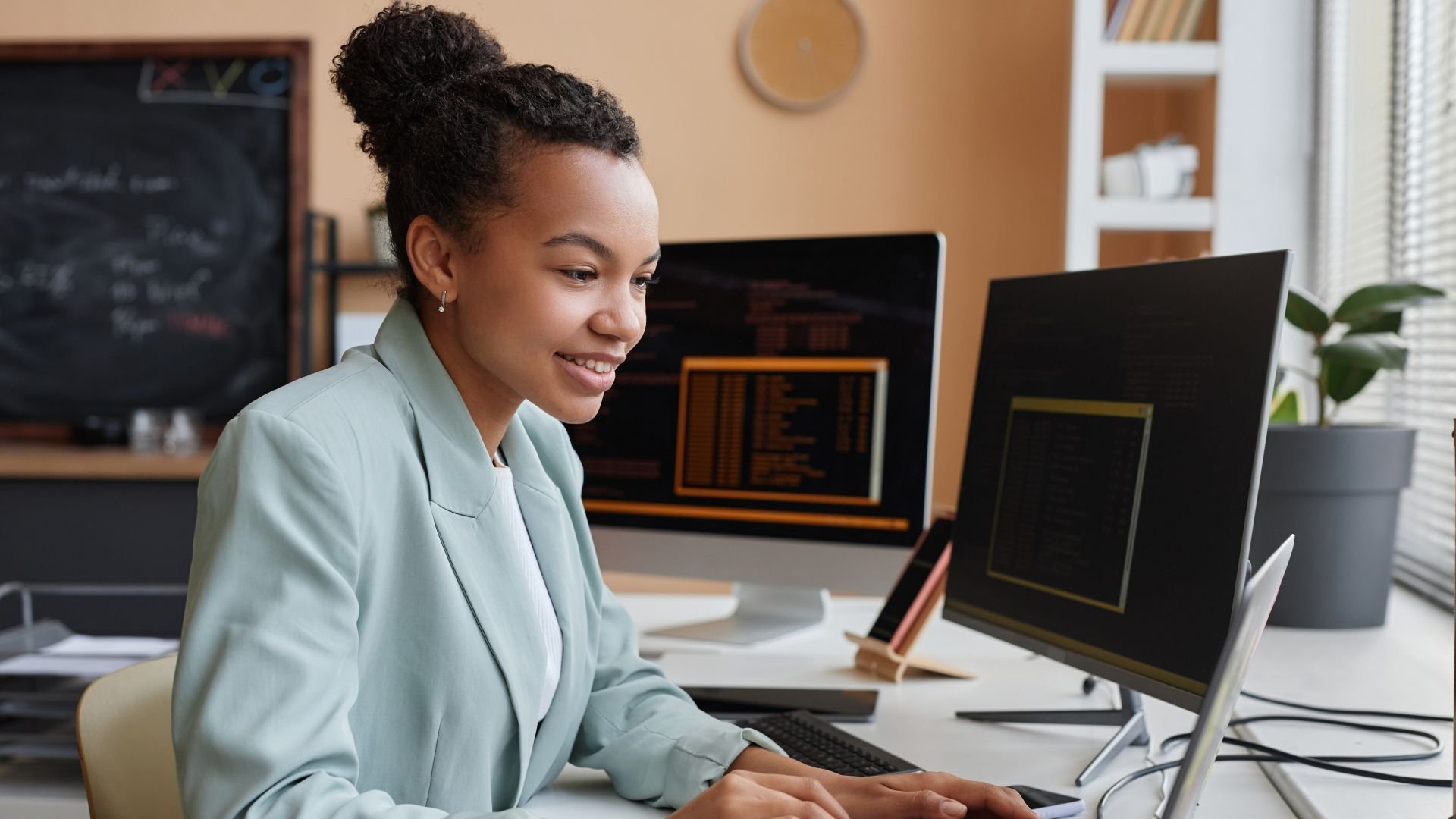 Woman working a laptop and monitors