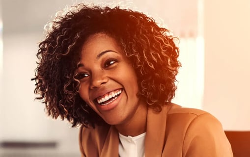 Woman smiling wearing a blazer.