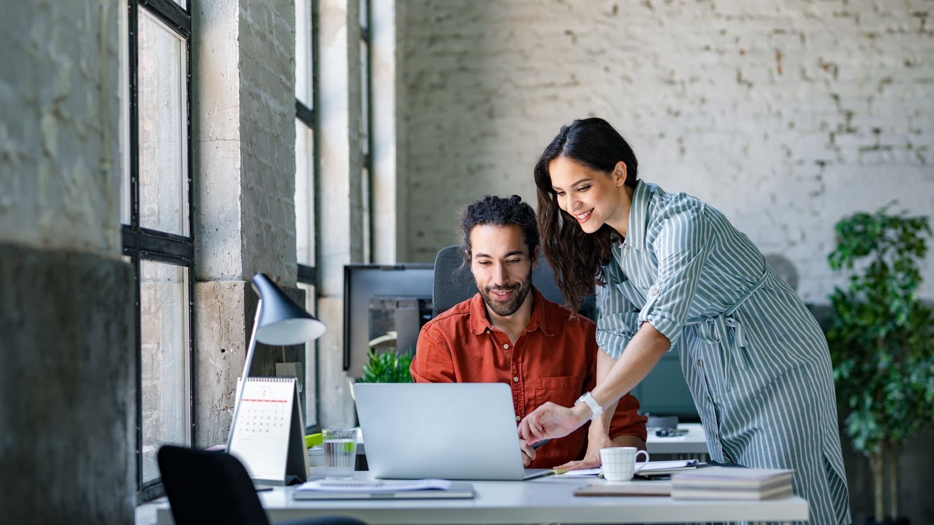 A man and a woman discussing over a laptop
