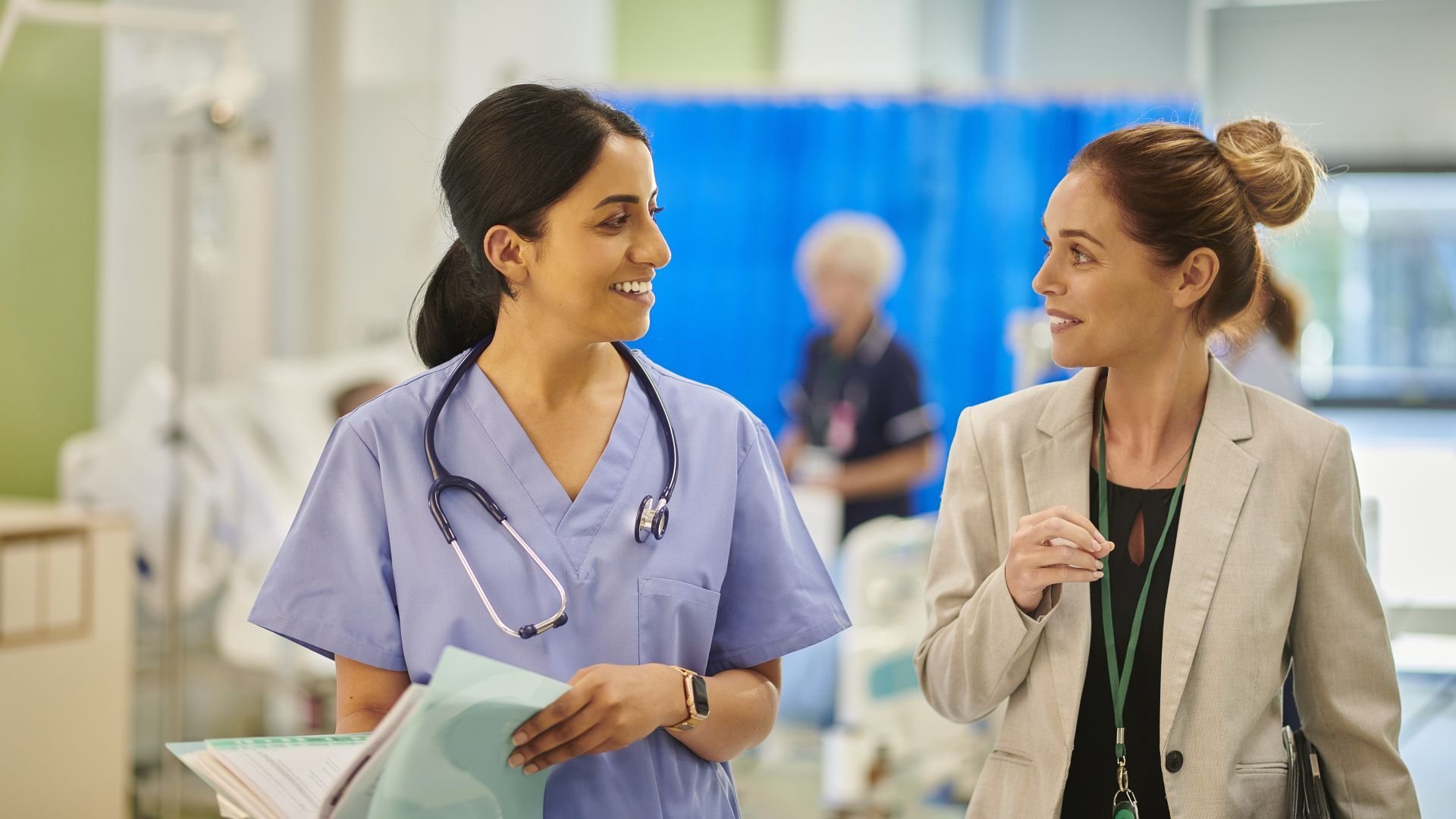 Two women in a healthcare environment walking and talking