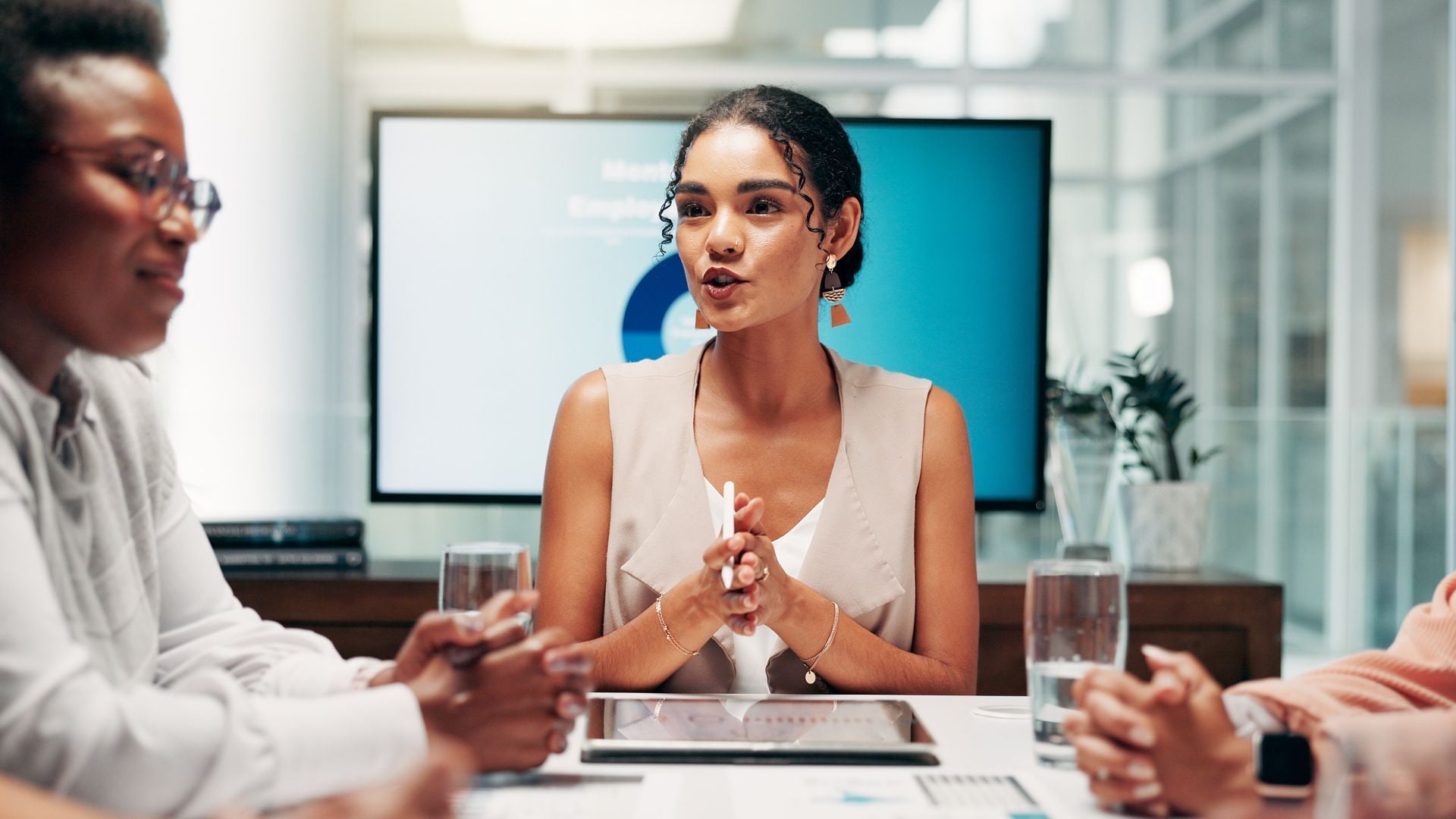 Woman chairing a meeting with screen behind her