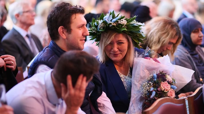 Celebrating Walbrook and LIBF graduate holds flowers at graduation ceremony in London