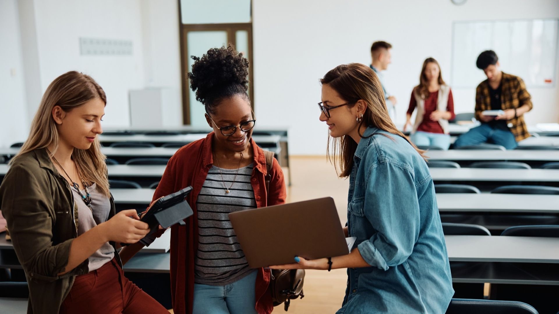 Three woman discussing something over a laptop