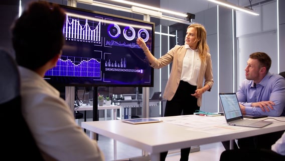 Three employees looking at data on a screen