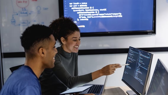 Two coworkers analyzing information on a computer