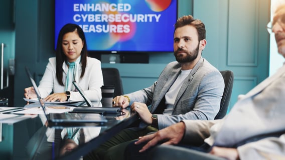 Three coworkers watching a cybersecurity presentation