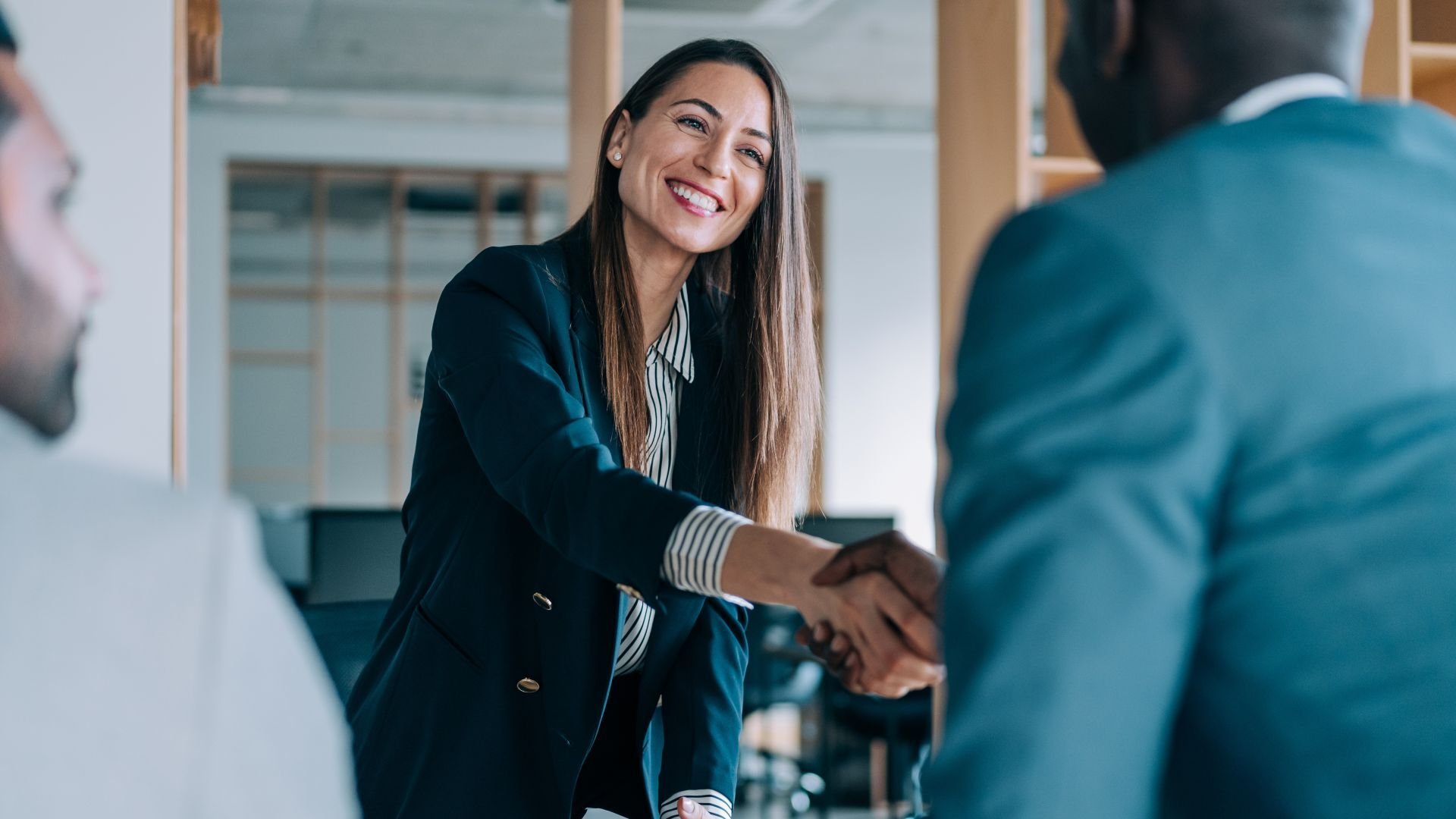 Man and woman shaking hands in office environment