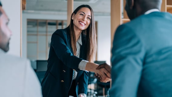 Man and woman shaking hands in office environment