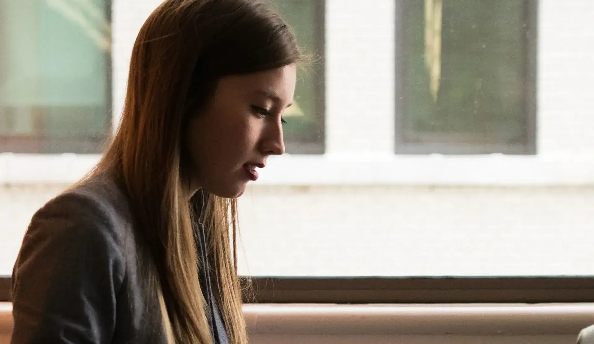 Young woman sitting with a laptop on her lap.