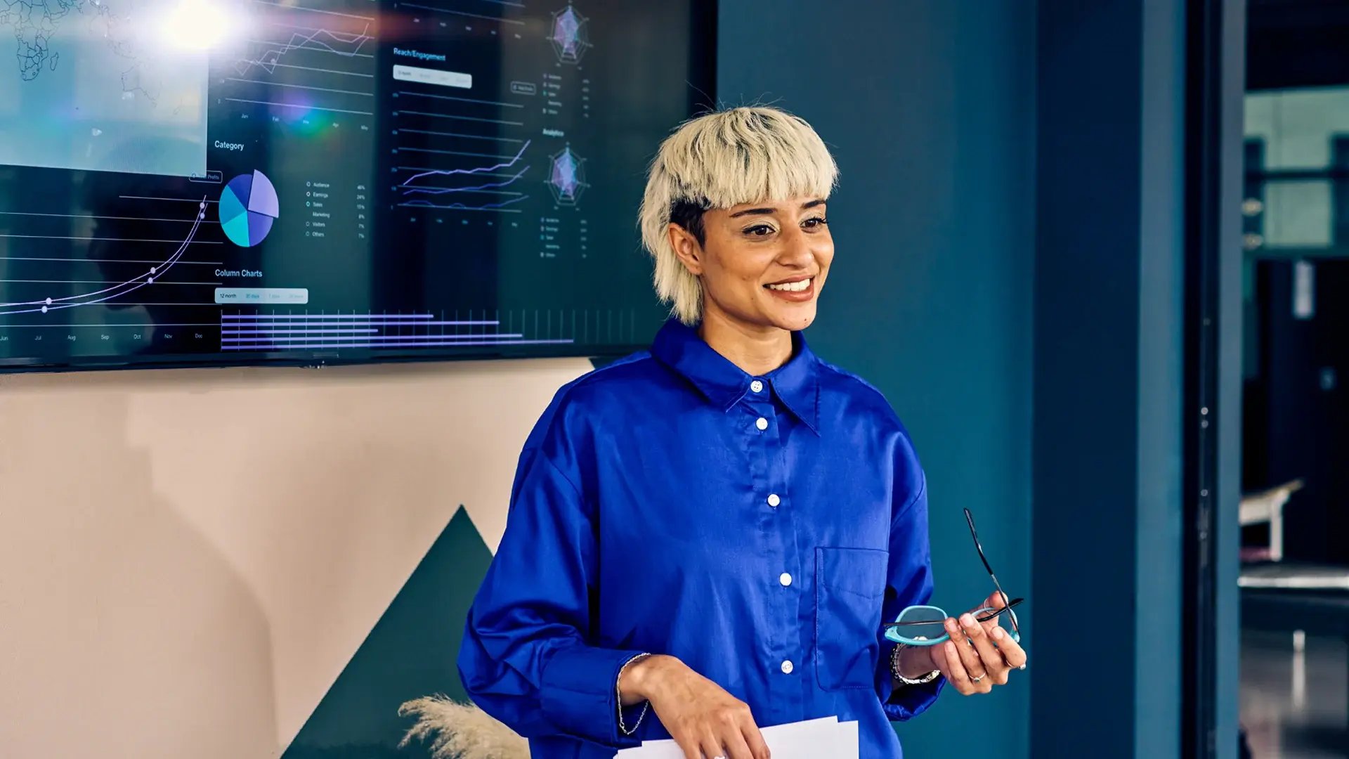 MSc Computer Science graduate in blue shirt presents data visualisation at their workplace.