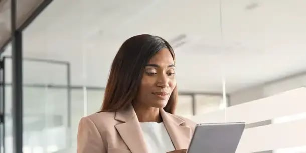 A young woman holding an iPad researching the available professional qualifications