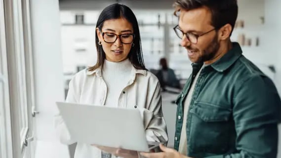Focused MBA Banking and Finance graduates analyse performance data together in a light-filled office session.