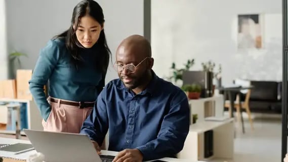 Online MBA alum collaborates on financial reports, combining analysis and teamwork in a modern workspace.