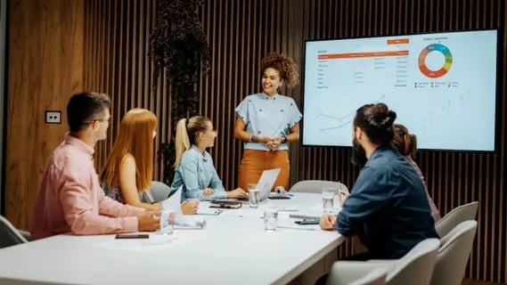 Confident MBA Project Management graduate guides a results-driven discussion using data visuals.