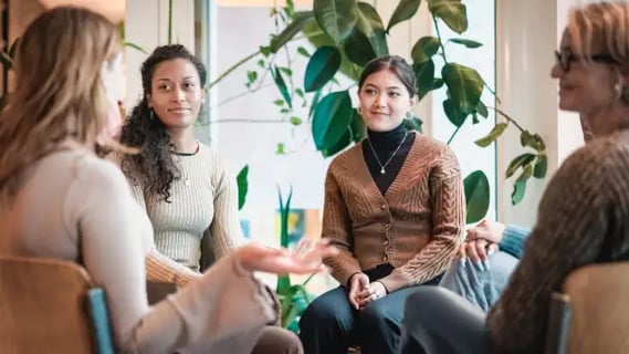 Group of women in modern office discuss positives of MSc psychological wellbeing