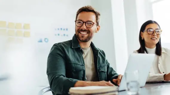 Confident MBA Project Management alum participates in a flexible workplace meeting, supporting team success.