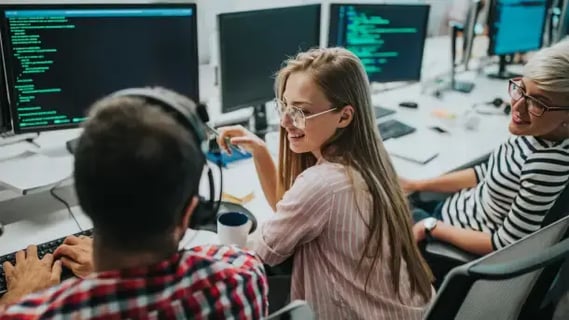 A group of young AI developers sat together developing ai-driven software.