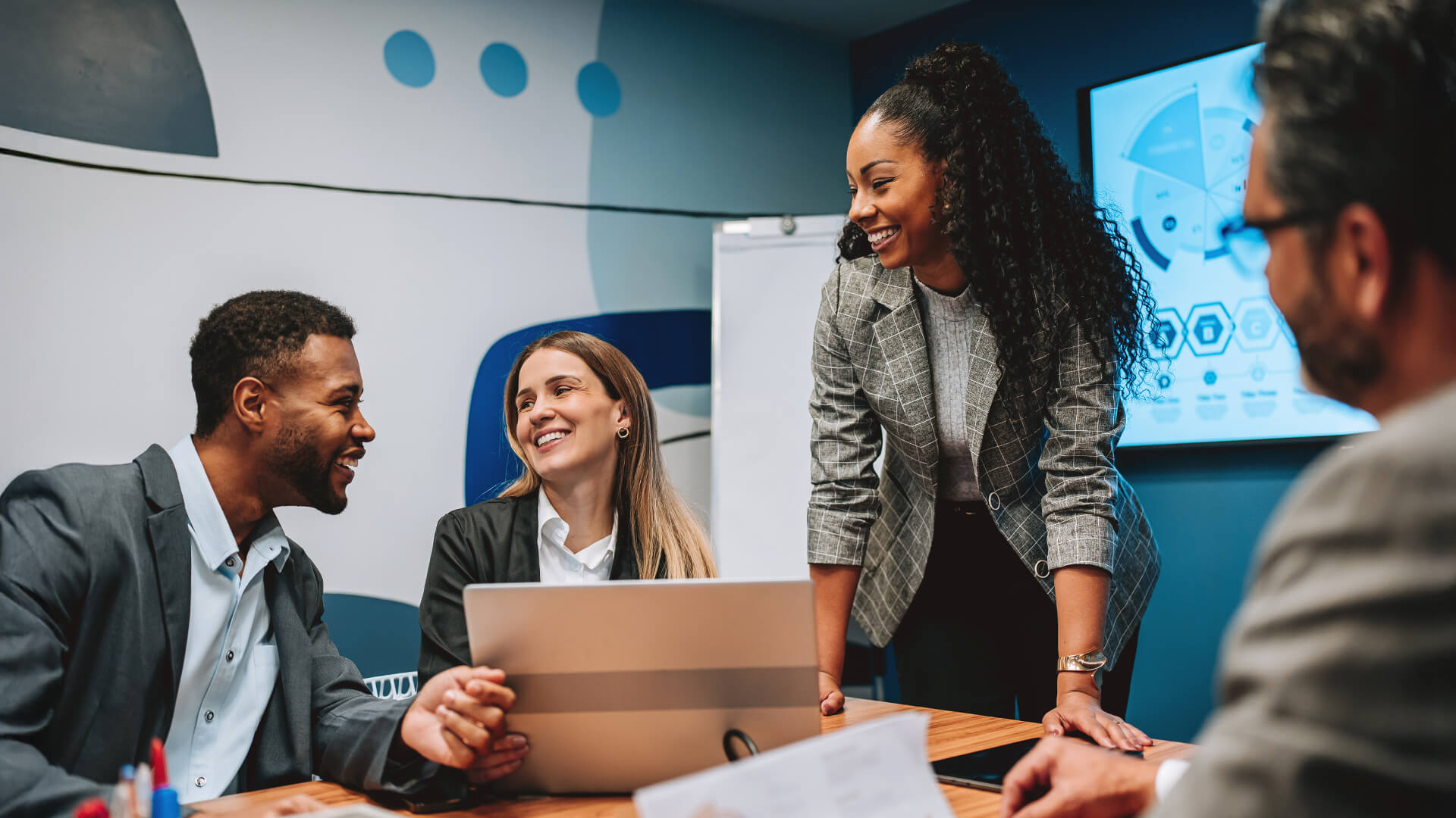 A group of professionals in a meeting room discussing security strategy, reflecting senior roles after an MBA Cyber Security.
